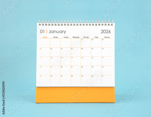 January 2026 white desk calendar on blue color background. Planning and goals concepts.