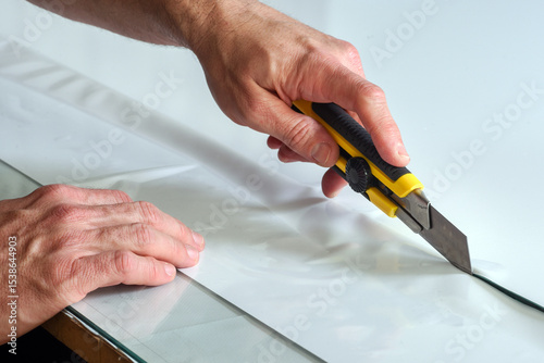 Wallpaper Mural Hands cutting material with yellow box cutter knife on flat surface Torontodigital.ca