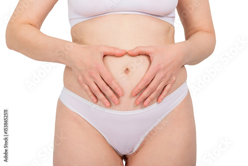 Woman making heart shape on her belly with her hands. Healthy digestion and gynecological health concept. Self-care and body awareness.