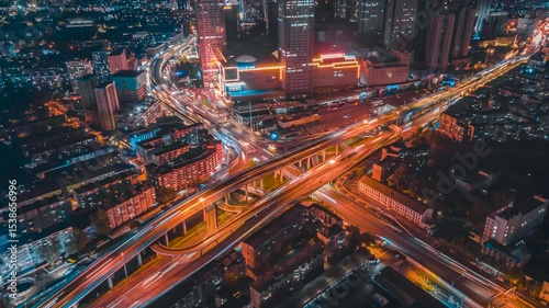 Aerial timelapse shows Shenyang Longemont City intersection traffic moving rapidly at night in Liaoning Province