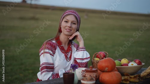 A joyful woman dressed in vibrant, colorful attire happily enjoys a bountiful feast of fresh, local produce