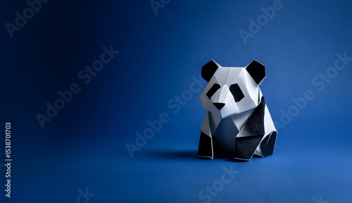 Creative origami panda figure in black and white against a vibrant blue backdrop, showcasing intricate paper folding techniques and artistic design