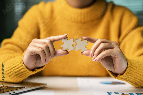 Concept of teamwork and cooperation in problem solving. Unity. Business team. Businesswoman holding wooden jigsaw to connect together. In problem solving. Charity. Volunteer.