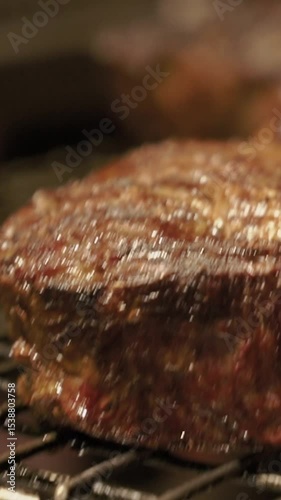 Meat juicy beef steak on fire is fried in an expensive restaurant. Hot dish barbecue raw on the bone with smoke