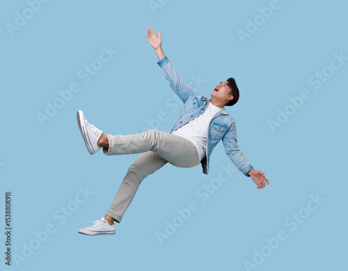 excited asian man relaxing floating in mid-air isolated on blue copy space background.