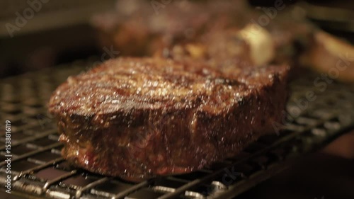 Meat juicy beef steak on fire is fried in an expensive restaurant. Hot dish barbecue raw on the bone with smoke