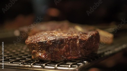 Meat juicy beef steak on fire is fried in an expensive restaurant. Hot dish barbecue raw on the bone with smoke