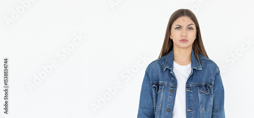 Hmm. Let me think. Studio shot of cute girl looking at camera with thoughtful and sly expression, raising one brow as if having good idea, planning something