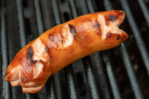 Gegrillter Cervelat mit eingeschnittenen Enden  auf dem Grill - Wurst