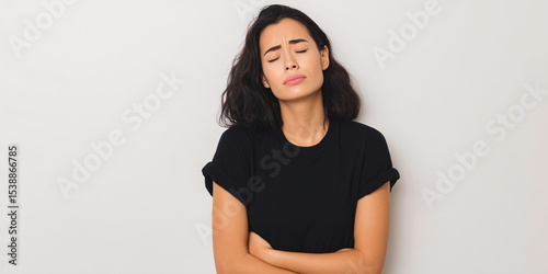Symptoms of nausea and discomfort woman clutching stomach with eyes closed in a neutral environment