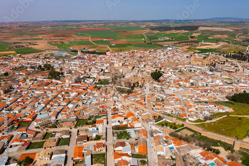 Aerial view of village of Belmonte in Spanish province of Cuenca surrounded by extensive farmland on spring day .. photo