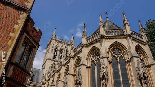 Architectural detail of St. John's College Chapel, a stunning example of the perpendicular gothic style, under a clear blue sky in Cambridge, UK photo