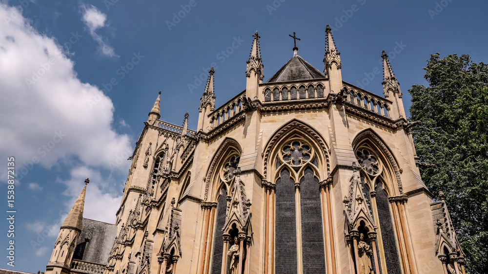 Naklejka premium Architectural detail of St. John's College Chapel, a stunning example of the perpendicular gothic style, under a clear blue sky in Cambridge, UK