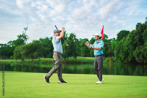 Senior Golfer and Young Player Celebrate Winning Moment on Green in Summer Golf Tournament for Family Bonding