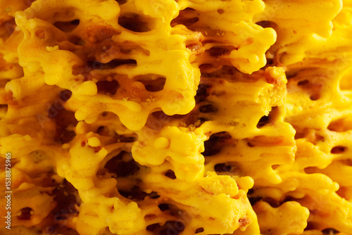 Extreme close-up of the textured surface of a Lithuanian Sakotis cake, highlighting its crispy golden layers and intricate structure. Perfect for culinary, texture, or food-themed projects.