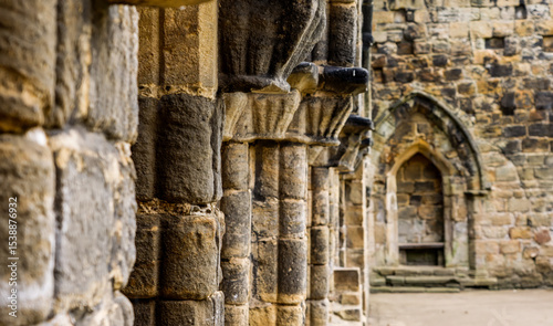 Architectural details showing weathered stone columns and arches in the ruins of Kirkstall Abbey, a cistercian monastery in Leeds, West Yorkshire, England