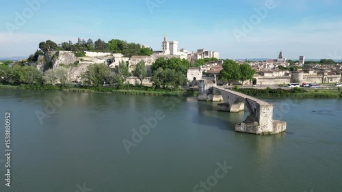 Pont d'Avignon medieval bridge with the city of Avignon, France in the background. The aerial shot shows the river and the ancient bridge in the foreground