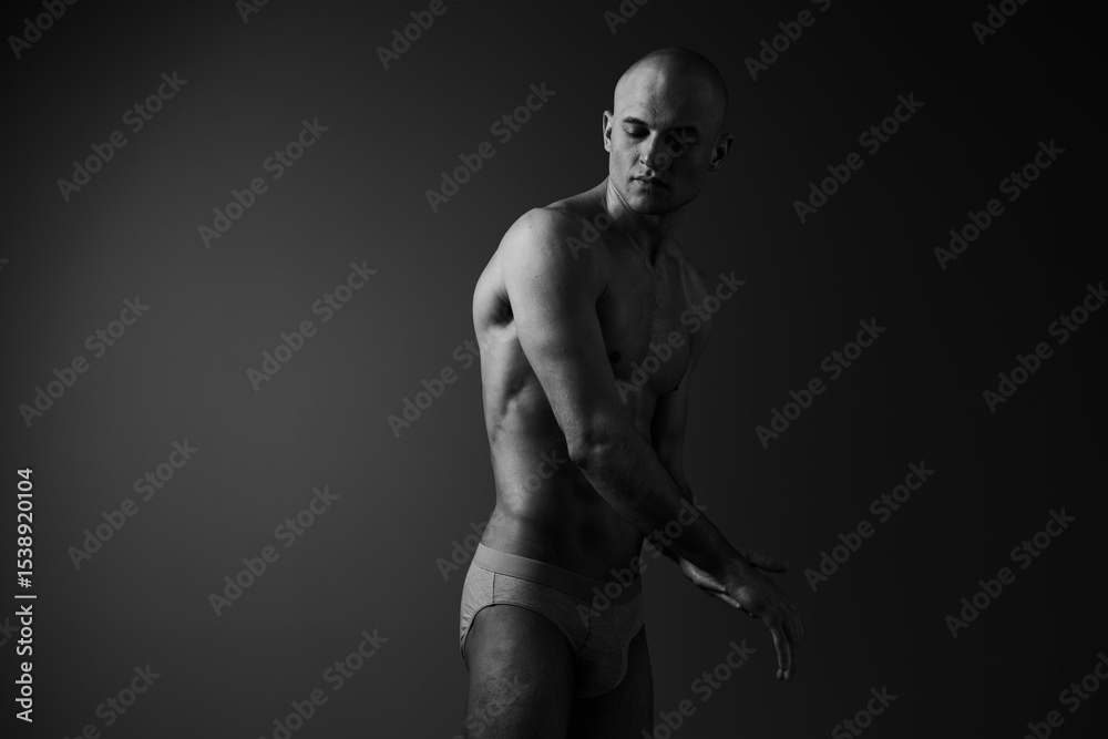 Naklejka premium Black and white image of a thoughtful man, showcasing elegance and strength through body language and posture, evoking a sense of introspection.