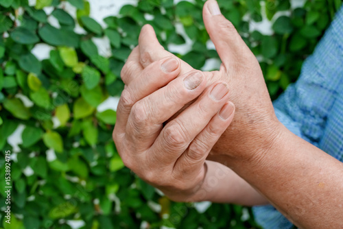 A woman uses her other hand to feel pain and tingling. along with Guillain-Barre syndrome and numbness in the hands Elderly woman tries to massage herself to relieve wrist pain