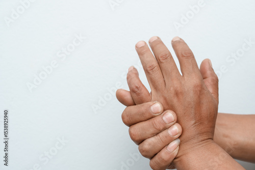 Foto A man uses his other hand to feel pain and tingling, along with Guillain-Barré syndrome and numbness in his hand