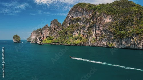 Aerial view of motorboats cruising through vibrant turquoise waters under a clear blue sky, Phi phi islands, Phuket, Thailand.