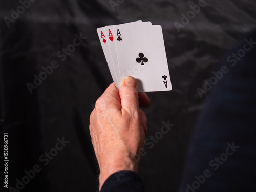 Poker player holding aces playing cards 