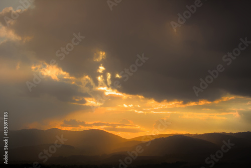 Dramatic sunset with sun rays breaking through clouds.