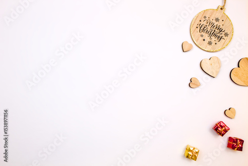 Festive flat lay with wooden Christmas decorations and small gifts.