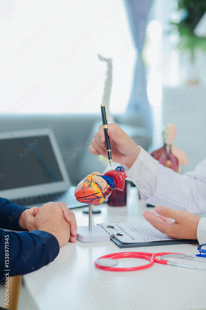 Fototapeta premium Female doctor gives advice and explanation to patient with dementia and stroke in examination room using human brain anatomy model and blood pressure measurement. Healthcare and medical concept. 