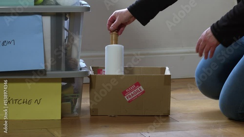 Woman moving fragile box into new home