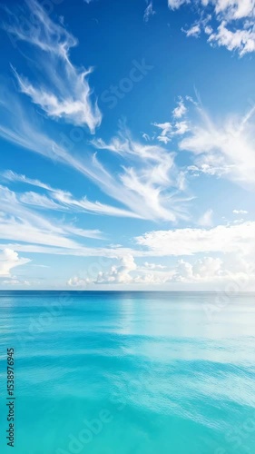 Wallpaper Mural Bright turquoise ocean stretches to the horizon with striking white cirrus clouds filling the clear blue sky in a serene tropical seascape. Torontodigital.ca