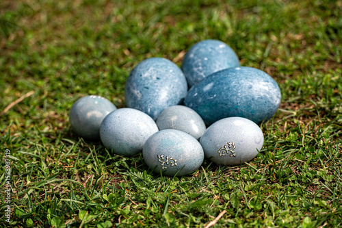 Decorative blue Easter eggs arranged on green grass during springtime celebration