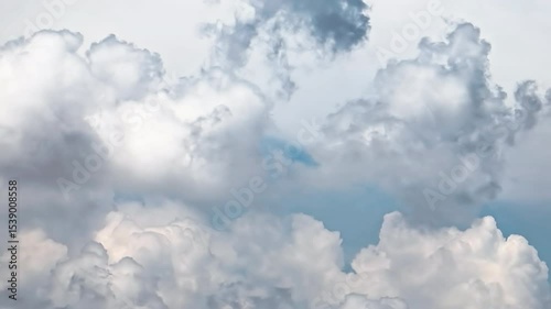 Beautiful white cumulus clouds floating in a vast blue sky on a bright day.