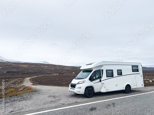 Exploring the nordic landscapes: a white camper van on a scenic road in norway, heading towards the arctic circle for an adventurous journey