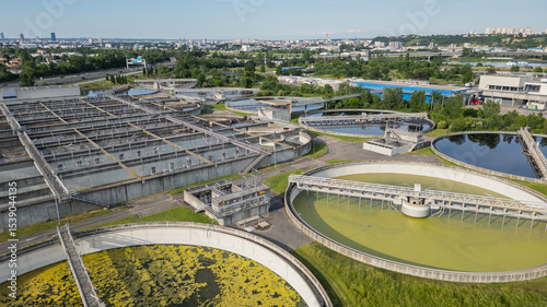 Eco-friendly aerial view of wastewater treatment plant near Lyon, France, with urban skyline – sustainable water management and environmental protection concept