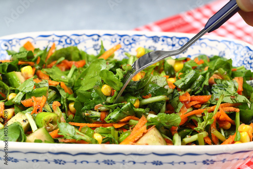 Mixed fresh Turkish salad. Carrots, arugula, cucumber, basil, pepper, black cumin, pepper, corn and plenty of olive oil in a serving plate. Healthy summer food.