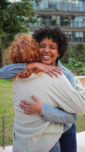 Two joyful women are embracing each other tightly, sharing bright smiles that reflect love and happiness, showcasing the beauty of friendship and connection in a heartfelt moment of affection.