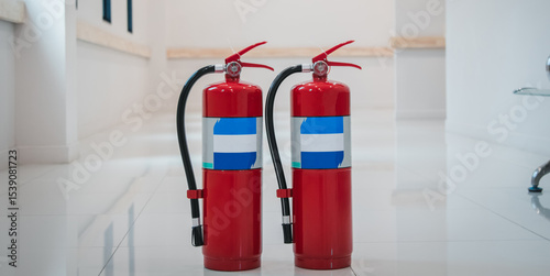 Fire extinguishers on floor available in fire emergency.