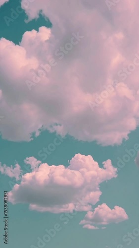Vertical video Cloudy pastel sky. Fluffy clouds moving on green, blue sky with clouds and sun. 4K Time lapse, Sky with clouds. Beautiful background