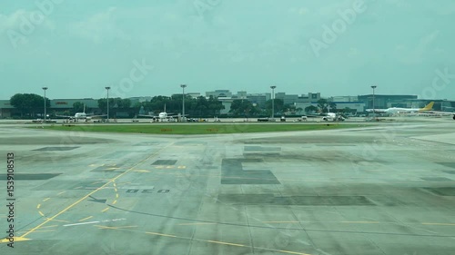 Airport tarmac view, distant buildings and parked vehicles