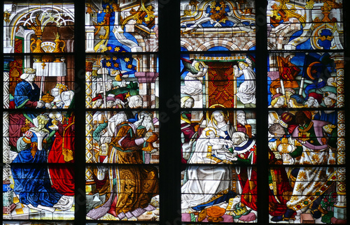 Quadro su tela Colorful stained glass window showing biblical scenes, including the Adoration o