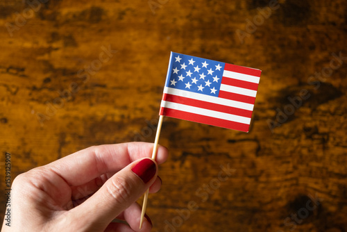 one woman hang holding American Flag over wood background