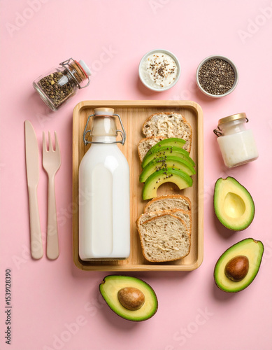 A millennial meal board featuring avocado toast, kombucha bottle, chia seed pudding, and pastel cutlery.