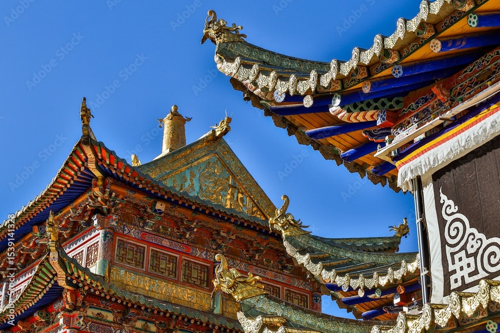 Fototapeta premium Intricate Tibetan architecture details of Taktsang Lhamo Monastery (Langmusi), a sacred Buddhist site in the Amdo region, showcasing vibrant ornamentation and traditional roof design.