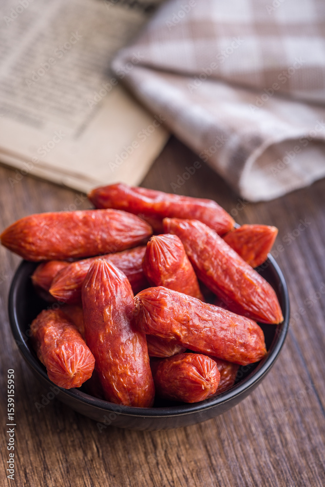 Mini salami sausages in bowl on wooden table. Mini salami sausages in bowl on wooden table.