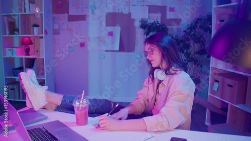 Remote Learning, Creative Focus, Gen Z Style. Student Works on Homework in Neon Room, Sketching by Laptop at Night. Calm Moment of Study, Visual Thinking, and Personal Expression