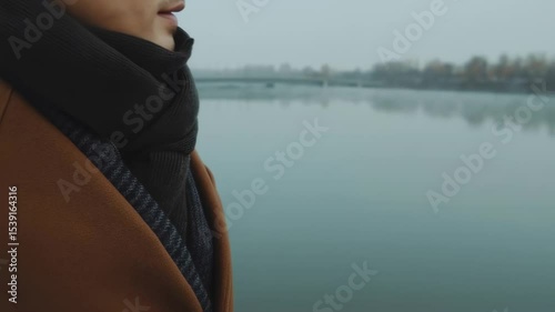 Slow motion portrait of a man standing by a foggy lake at dawn.  
