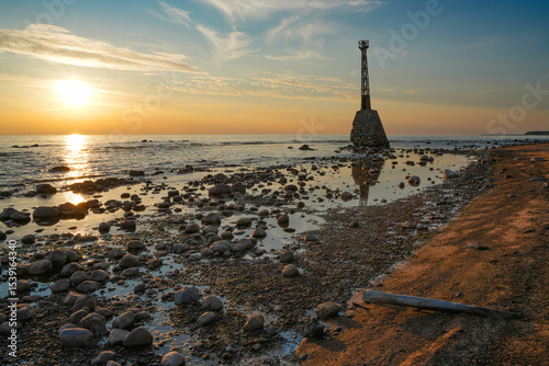 Fototapeta Naklejka Na Ścianę i Meble -  leaning lighthouse on the seashore at sunset