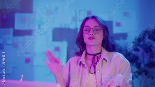 Work-Life Balance, Digital Lifestyle, Neon Mood. Young Woman in Creative Home Office Joins Business Video Call. Calm Focus and Comfort in a Modern Flexible Work Environment