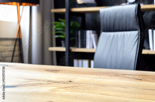 Modern business office with leather chair and wooden desk in front of elegant bookshelf with decor and books. Workspace interior for executive or entrepreneur